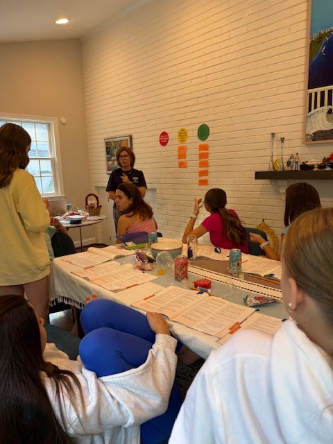 Students practicing baby care skills on dolls during a class